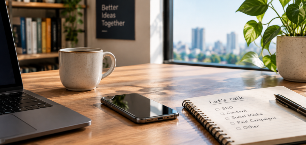 Digital marketing specialist contact workspace with notebook, laptop, and coffee mug
